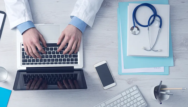 PRP Orthopedic Doctor making platelet-rich plasma therapy notes on laptop